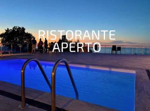 people standing around a swimming pool with the words recommend opera at Frontemare Hotel Village & Ristorante in Rodi Garganico