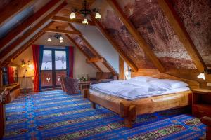 ein Schlafzimmer mit einem großen Bett im Dachgeschoss in der Unterkunft Wellness Penzion Strachan in Ždiar