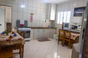 una cocina con mesa y una cocina con mesa y sillas en Recanto do Zezé, en Gonçalves