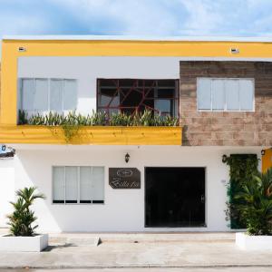 a white building with a yellow roof and a balcony at Hotel Bella Isa in La Dorada