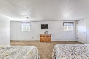 a bedroom with two beds and two windows at Bright 2-Story Condo 8 Mi to Grindstone Lake in Ruidoso Downs