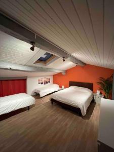 ein Schlafzimmer mit 2 Betten und einer orangefarbenen Wand in der Unterkunft Gîte au cœur des vignes in Bourg-sur-Gironde