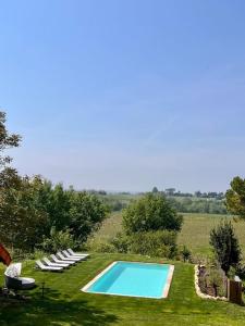 eine Gruppe Stühle und ein Pool im Gras in der Unterkunft Gîte au cœur des vignes in Bourg-sur-Gironde