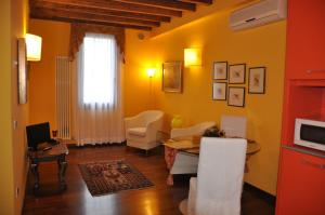 a living room with yellow walls and a table and chairs at Piazza Nova Guest House in Ferrara