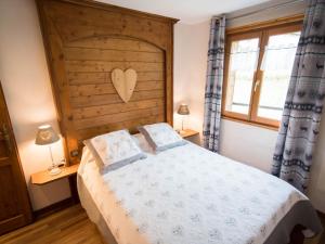 ヴォントロンにあるCharming Chalet in Ventron with Terraceのベッドルーム1室(大型ベッド1台、木製ヘッドボード付)