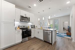 a kitchen with white cabinets and black appliances at Luxury Central Apts - Free Parking, Gym, Fast WiFi in Austin