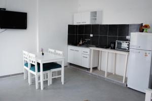 a kitchen with white cabinets and a table and a refrigerator at Departamento Génesis, 1er piso in Chilecito
