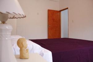 1 dormitorio con 1 cama con una estatuilla sobre una mesa en Departamento Génesis, 1er piso en Chilecito