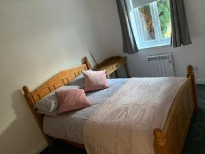 a bedroom with a wooden bed with pink pillows at Monkbridge York City Centre with parking in York