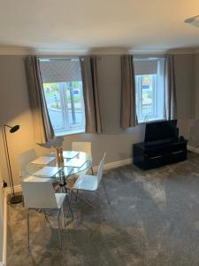 a dining room with a table and chairs and windows at Monkbridge York City Centre with parking in York
