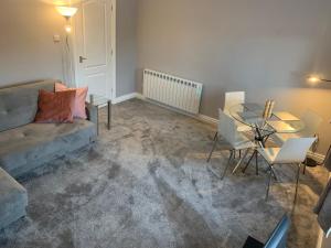 a living room with a couch and a glass table at Monkbridge York City Centre with parking in York