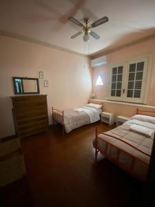 um quarto com 2 camas e uma ventoinha de tecto em Casa a mare em Calatabiano
