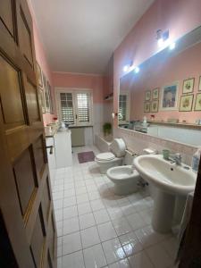 uma casa de banho rosa com 2 WC e um lavatório em Casa a mare em Calatabiano