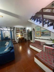 uma grande sala de estar com sofás e uma escadaria em Casa a mare em Calatabiano