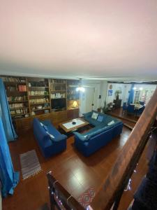 uma sala de estar com dois sofás azuis e uma mesa em Casa a mare em Calatabiano