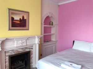 a bedroom with a bed and a fireplace at Lyttleton Lodge in Uxbridge