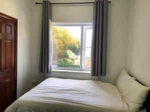 un letto in una camera da letto con finestra di Lyttleton Lodge a Uxbridge