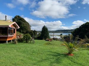 uma casa num relvado com vista para a água em Cabañas Sol Del Mar em Ancud