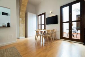 a living room with a table and chairs and a tv at CASA PALACIO SUR in El Puerto de Santa María