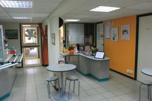 um restaurante com mesas e bancos numa cafetaria em Hôtel Premiere Classe Pamiers em Pamiers