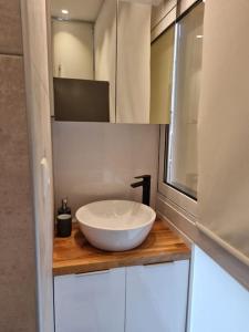 a bathroom with a white bowl sink on a wooden counter at Modern studio apartment A in Athens