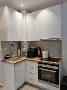 a kitchen with white cabinets and a sink at Modern studio apartment A in Athens