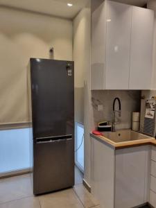 a kitchen with a stainless steel refrigerator and a sink at Modern studio apartment A in Athens