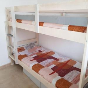 a white bunk bed with a quilt on it at Saint Martin Appartement Duplex Proximité Immédiate Mer & Commerces in Bréhal