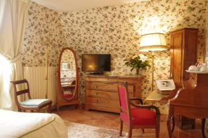 a bedroom with a bed and a desk with a television at Domaine De Chatenay - Le Mans in Saint-Saturnin