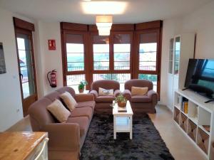 a living room with a couch and a tv at El Mirador de La Hayuela, a 7 min de Comillas in Comillas