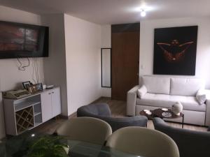 sala de estar con sofá blanco y sillas en Macondo-Habitación zona céntrica, en pleno corazón, en Bogotá