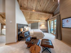 a bedroom with a bed and a tv and a chair at Chalet Méribel, 7 pièces, 12 personnes - FR-1-566-44 in Les Allues