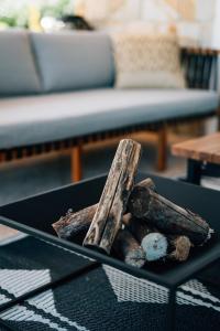 einen Korb mit Holzscheiten auf einem Tisch im Wohnzimmer in der Unterkunft Archi Bianchi in Cefalú