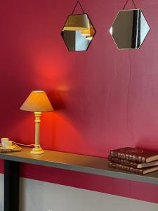una lámpara sobre una mesa con una pared roja en Le Show Room, en Auxerre