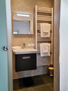 a bathroom with a sink and a mirror and towels at Ferienwohnungen Margreiter Birgit in Hart im Zillertal