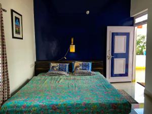 Schlafzimmer mit einem Bett mit blauer Wand in der Unterkunft Comfort and Cozy in Orchha