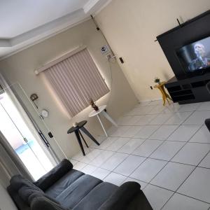 a living room with a couch and a tv at Casa Park Massangano in Petrolina