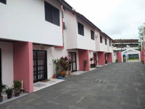 an empty courtyard of a pink and white building at Triplex em Caiobá-Matinhos-Pr a 200 mt do mar in Matinhos