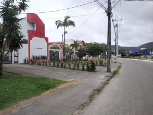 an empty street with a red building on the side of a road at Triplex em Caiobá-Matinhos-Pr a 200 mt do mar in Matinhos