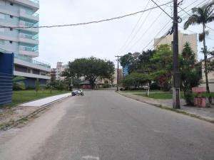 an empty street with a car parked on the side of the road at Triplex em Caiobá-Matinhos-Pr a 200 mt do mar in Matinhos