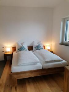 two beds in a room with two lamps on both sides at Ferienwohnungen Margreiter Birgit in Hart im Zillertal