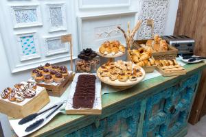 a buffet filled with different types of pastries and desserts at H2otel By LD Hotel Boutique in La Mira