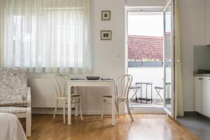 een kleine woonkamer met een tafel en stoelen bij Apartman BeBe in Zagreb