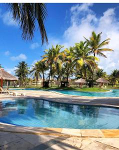 una piscina con palmeras en el fondo en Ap Aquaville resort -CE, en Aquiraz