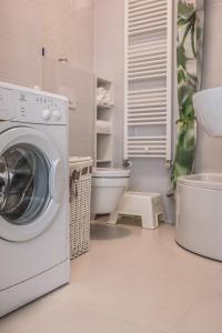 eine weiße Waschküche mit einer Waschmaschine in der Unterkunft Apartman BeBe in Zagreb