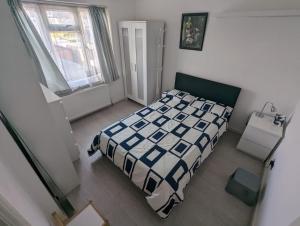 a bedroom with a bed with a blue and white comforter at Spacious 2 bedroom house with garden in Edmonton