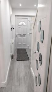 a hallway with a white door and a rug at Spacious 2 bedroom house with garden in Edmonton