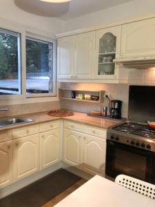 a kitchen with white cabinets and a stove top oven at 15 min - CDG et Paris in Aulnay-sous-Bois