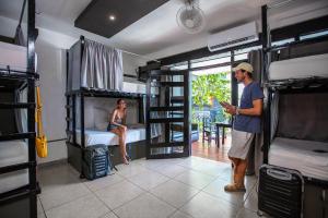 a man is standing in a room with bunk beds at Che Playa Hostel & Bar Adults Only in Playa del Carmen