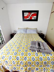 Schlafzimmer mit einem Bett mit gelber und blauer Tagesdecke in der Unterkunft Habitaciones en Miraflores - Departamento compartido Maka's Home in Lima